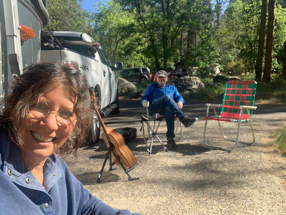 Helene and Ofer at a campsite with an acoustic guitar